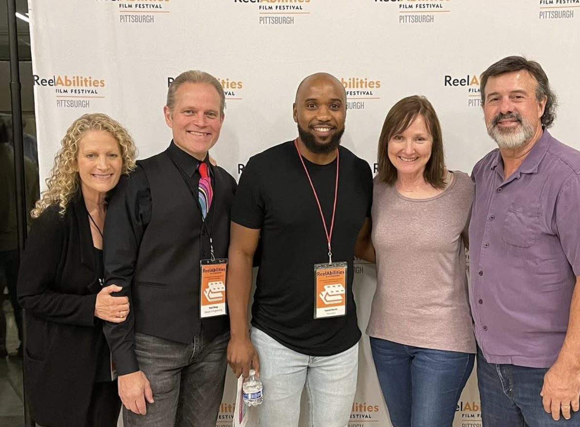 Isaiah with festival organizers at ReelAbilities Film Festival Pittsburgh