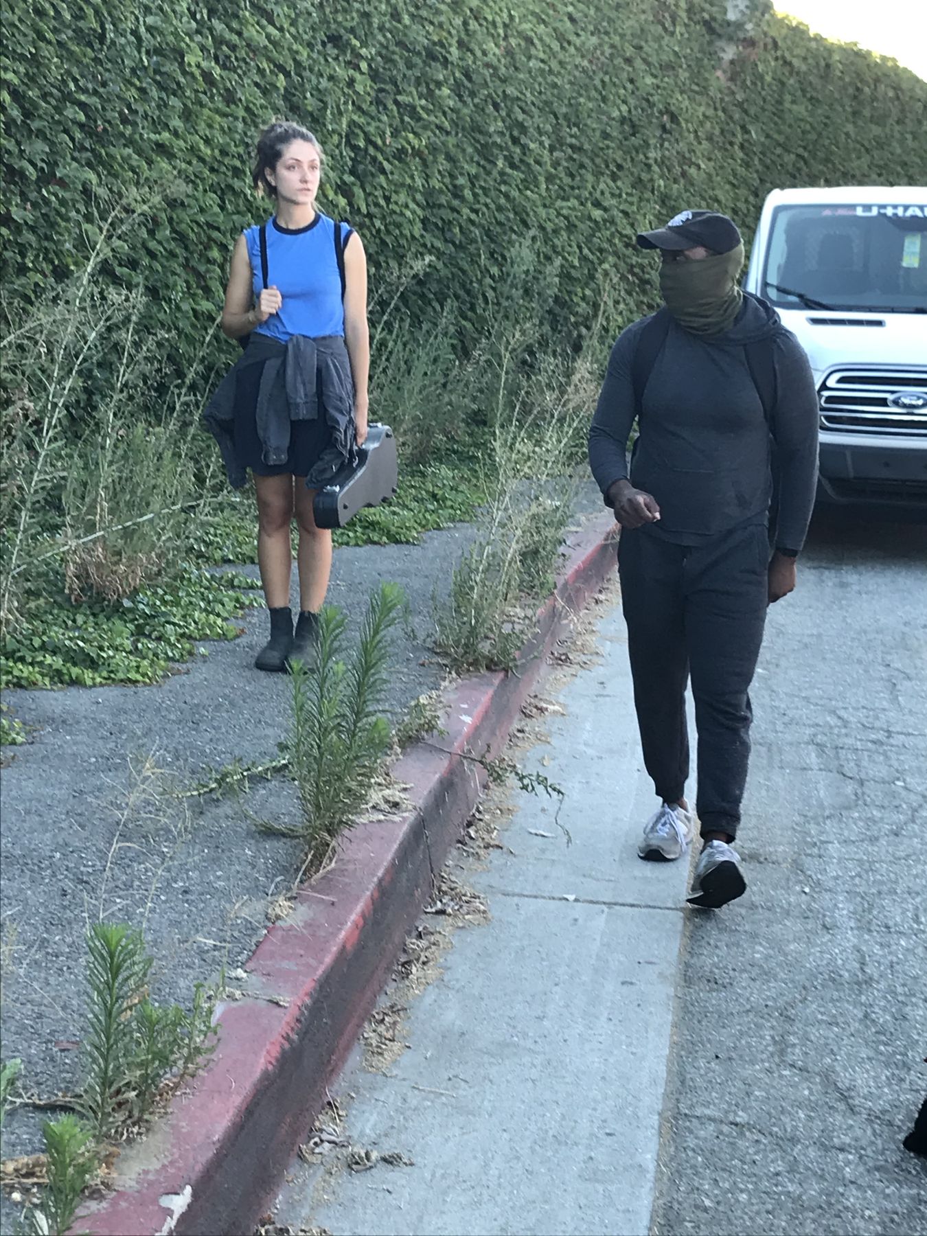 Isaiah walking a scene with an actor on a hillside road